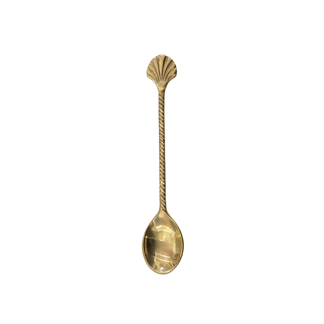 Gold spoon with shell design on a white background