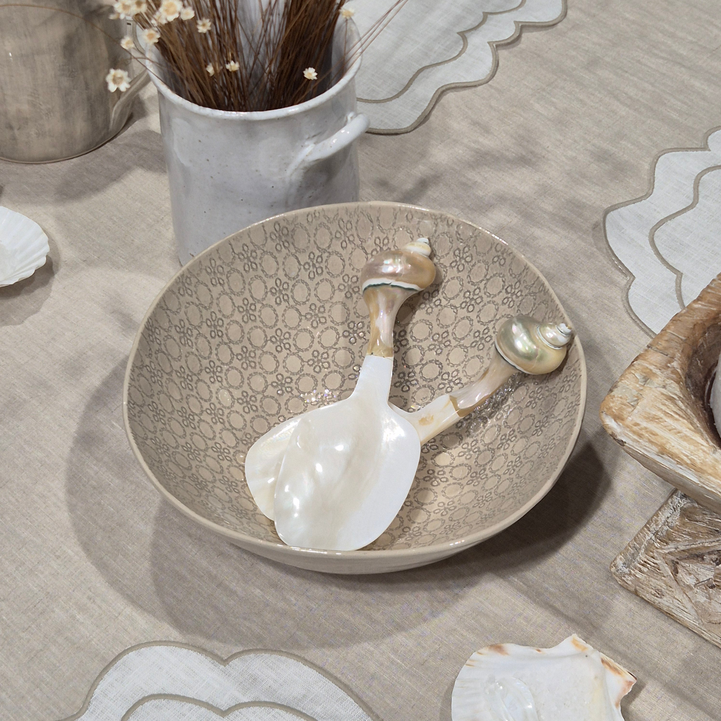 Decorative ceramic bowl with shell designs on a textured surface